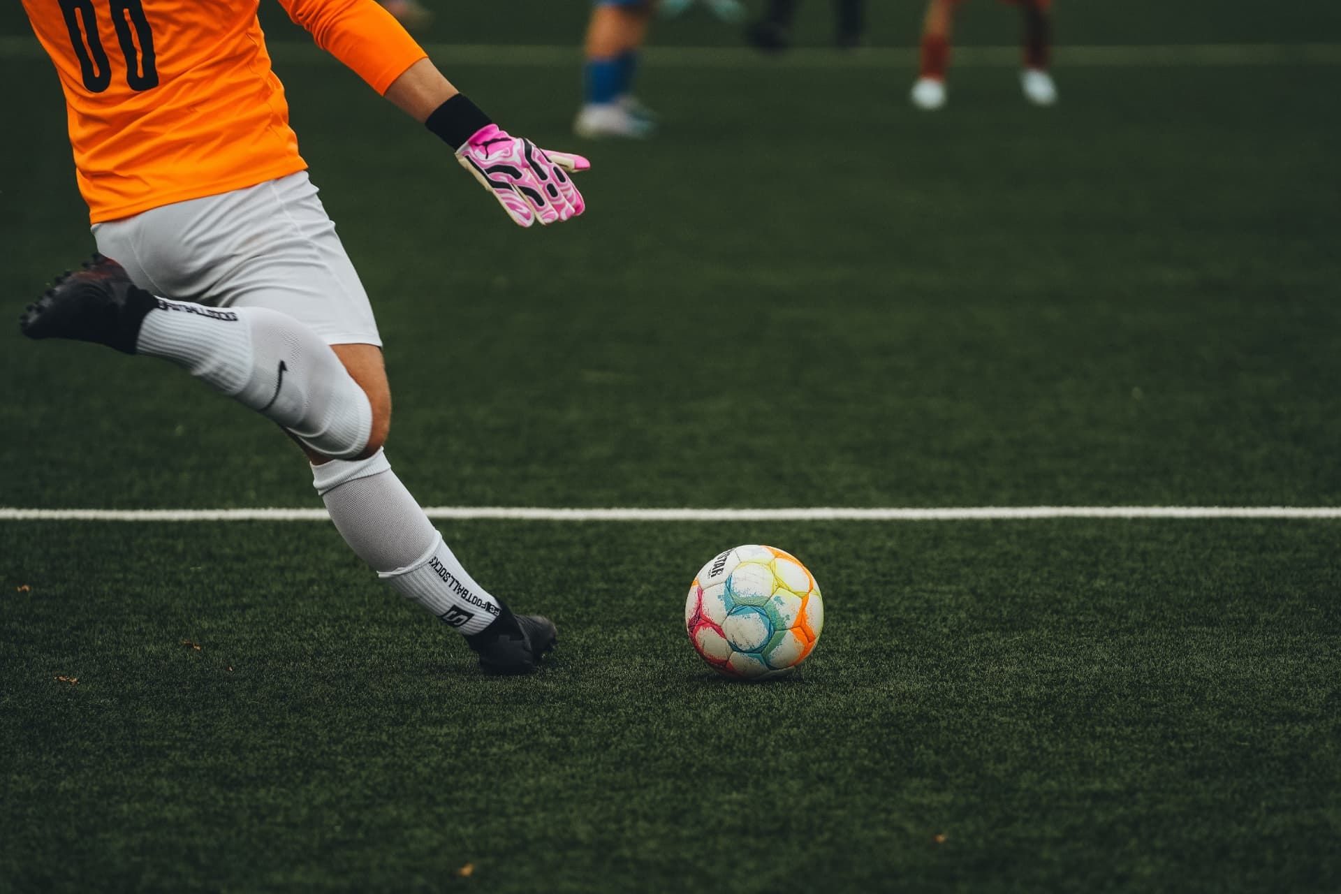 Goalkeeper striking a football on an artificial turf pitch. Not the Sector 92 project.