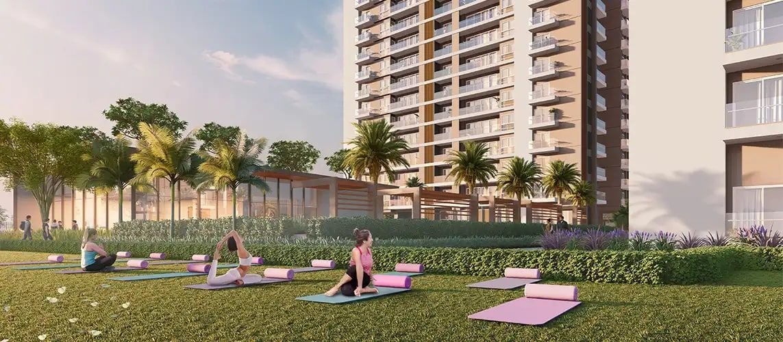Residents doing yoga on a lawn beside mid-rise residential blocks.